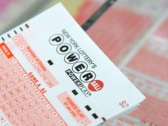 Powerball头奖在周末没有中奖者后攀升至740万美元 A ticket for the Powerball lottery sits on a counter in a store
