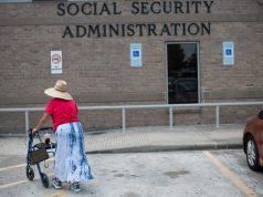 社会保障受益人中的一些人将在十二月获得2份每月福利支票 Woman with walker heads into Houston Social Security office